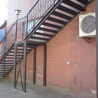 Уличная металлическая лестница на второй этаж с площадкой из двух маршей..